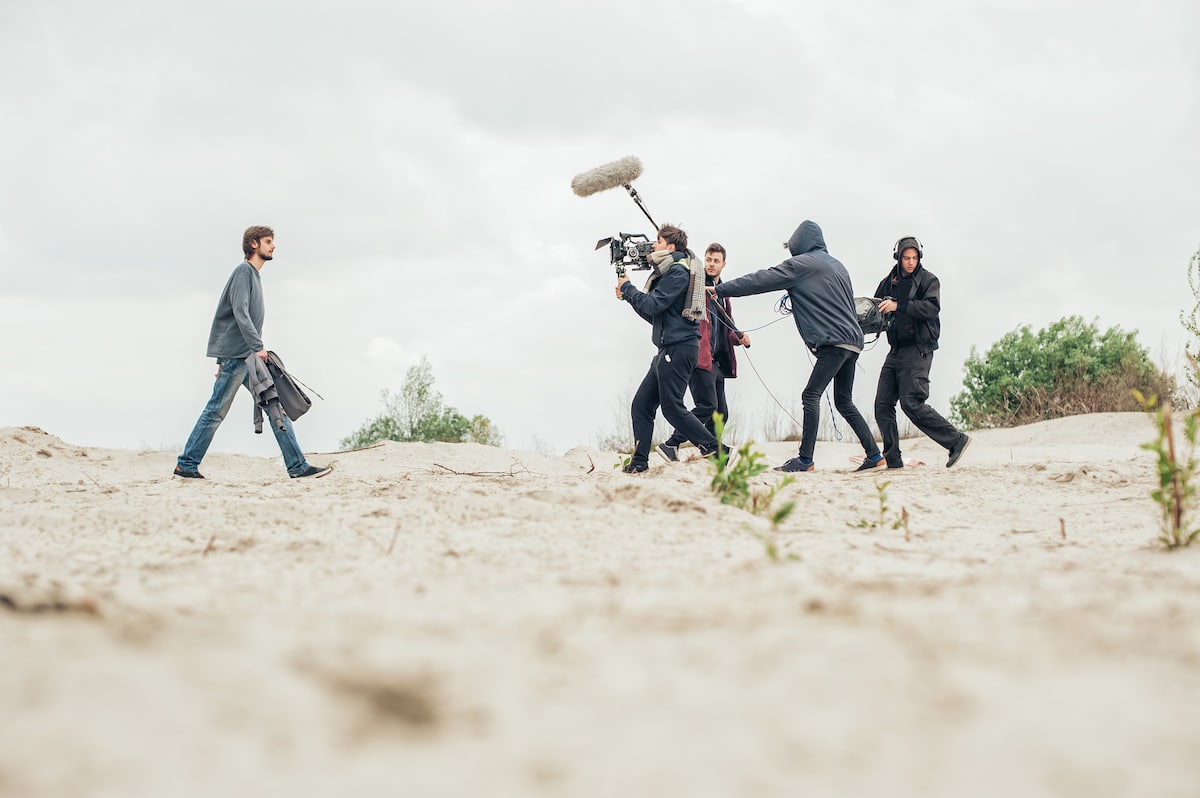 Behind the scene. Film crew filming movie scene outdoor location scout's view out of airplane window overlooking island