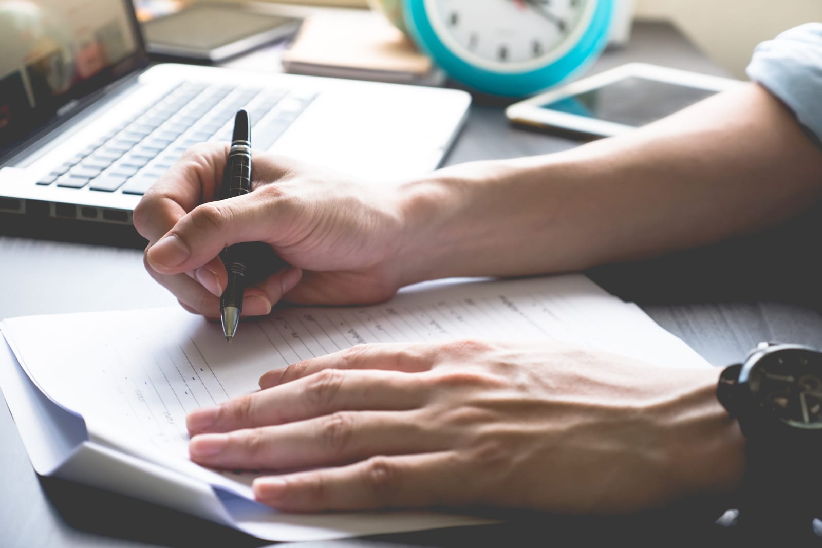 Close up of male hands writing on paper on his office desk. Man writing screenplay for animation