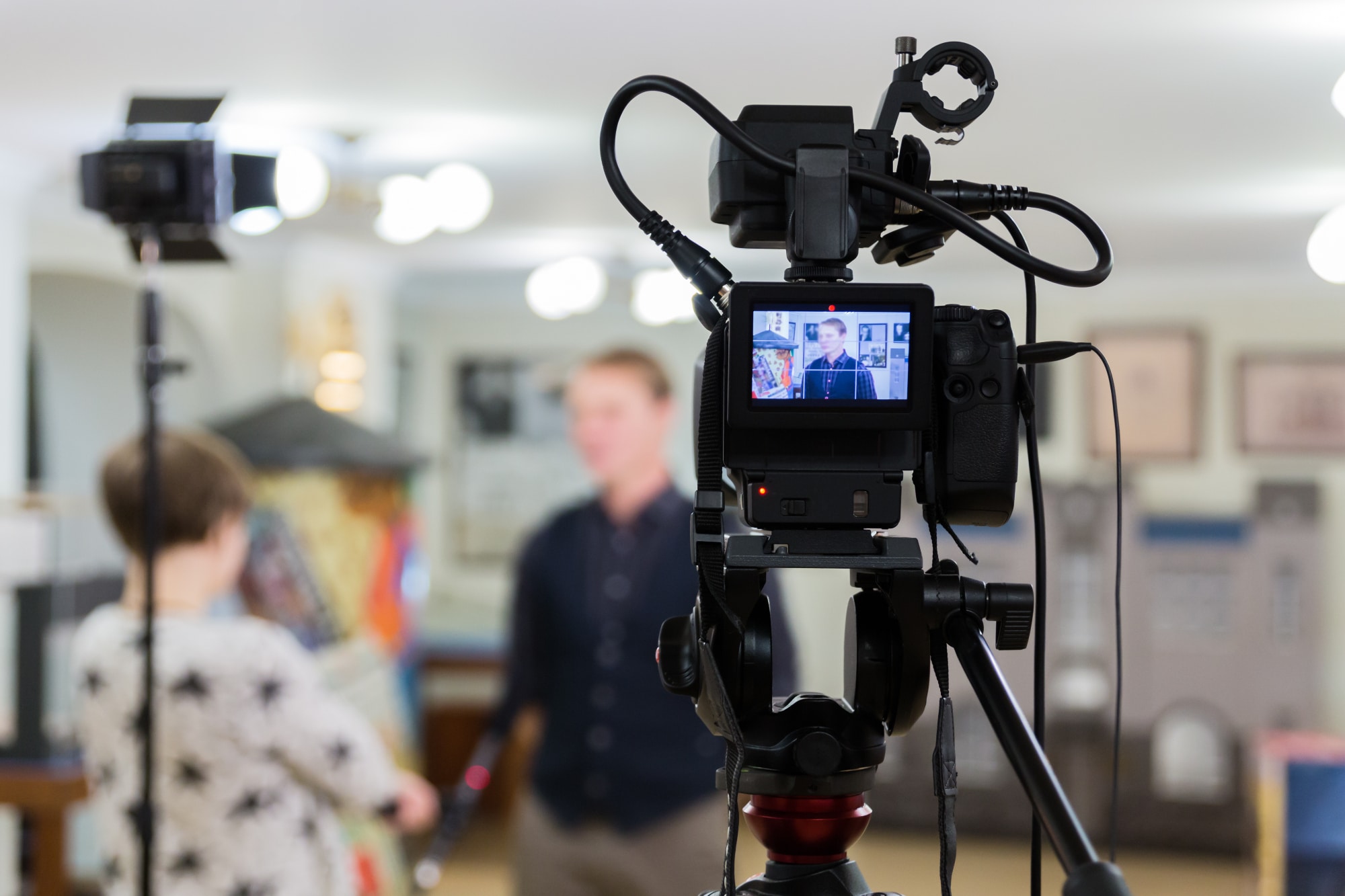 Marketing team recording a promotional video with lighting and camera setup.