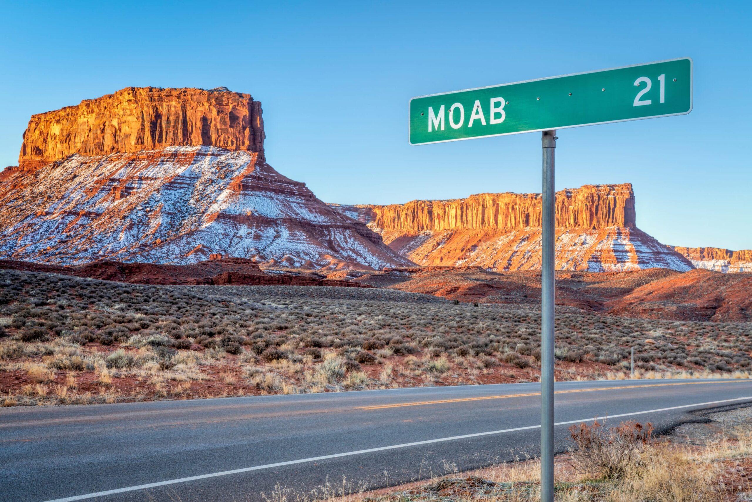 Road sign for Moab, Utah, with the desert landscape in the background.