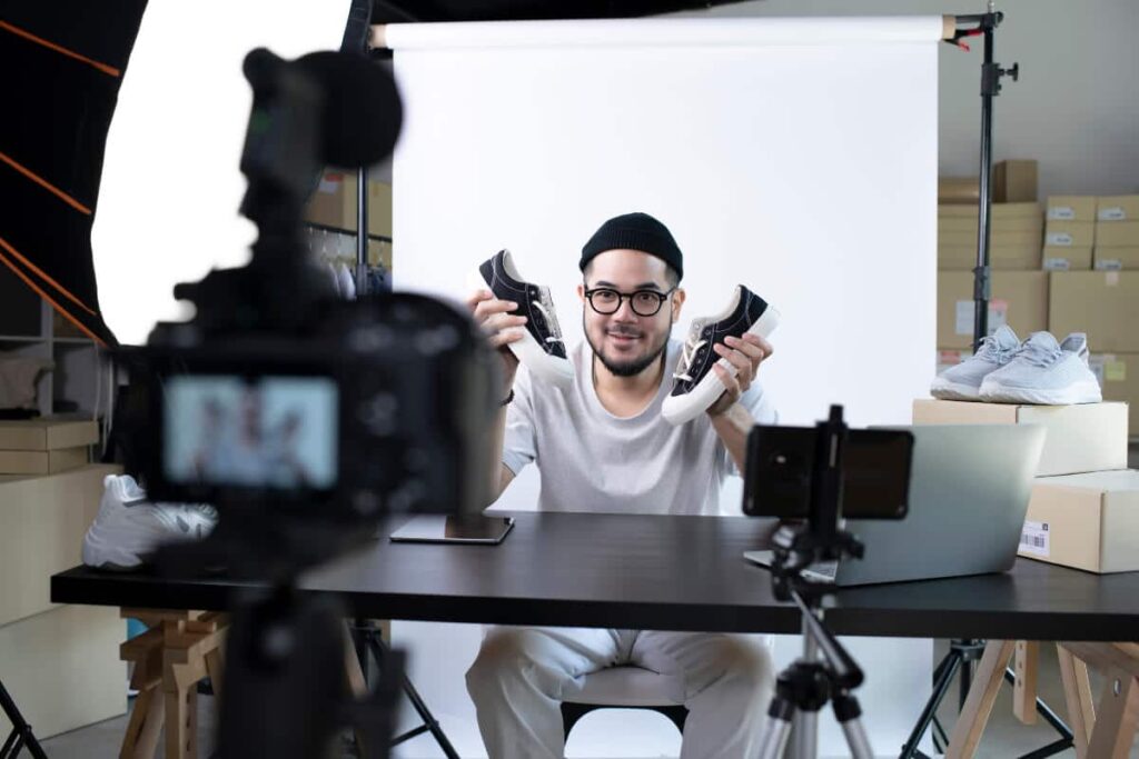 Production team filming explainer video of man outlining his shoe product