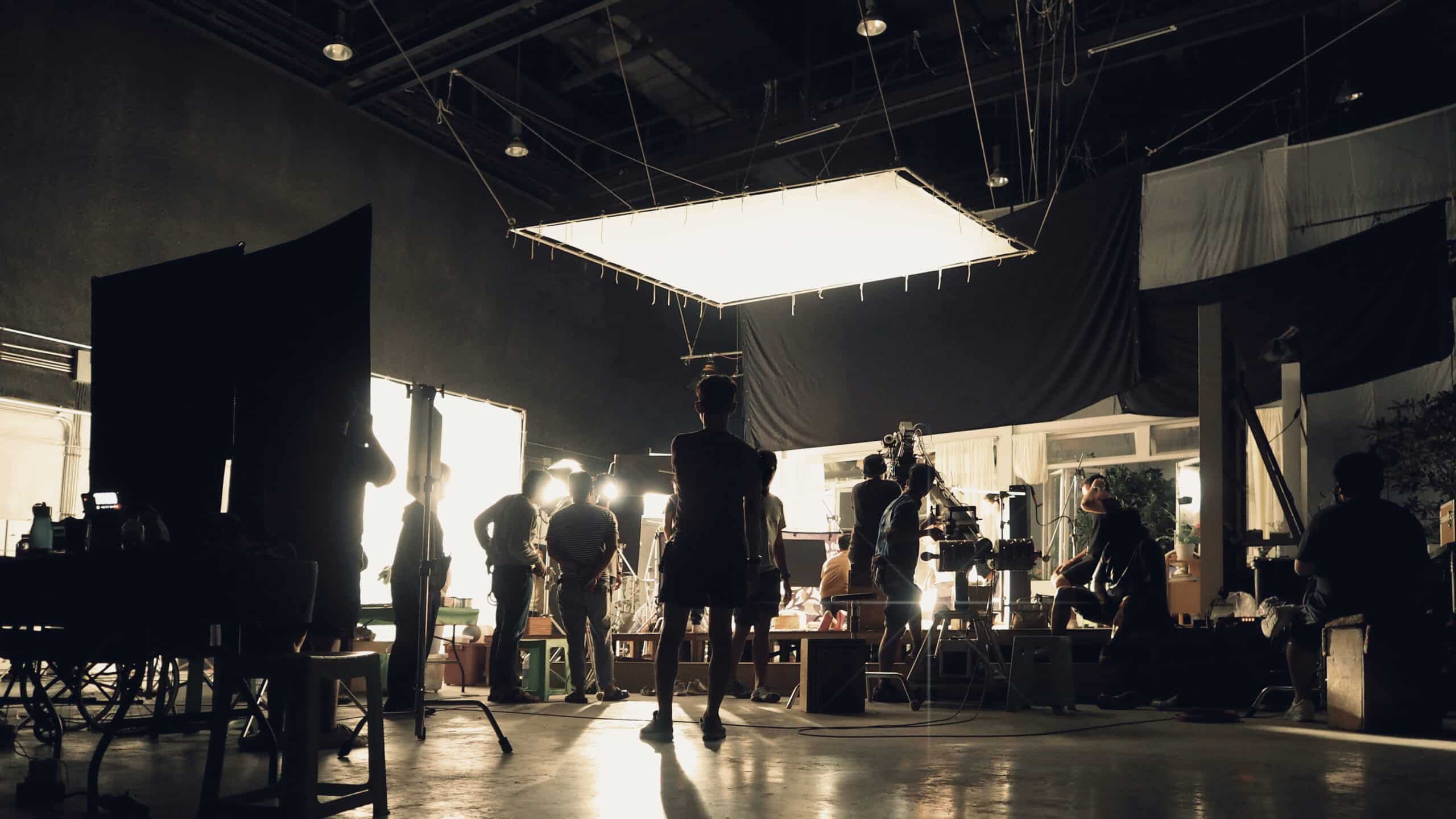 Behind the scenes of people working in a full-service video production studio making a movie, film, or video commercial.